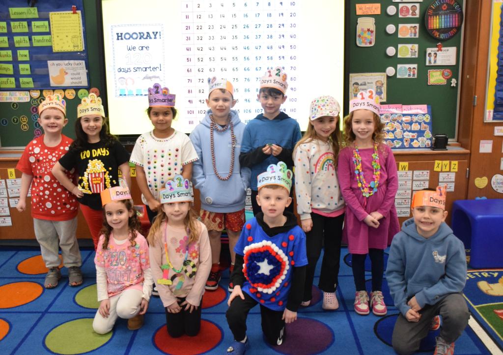 kids sitting on carpet smiling wearing crowns
